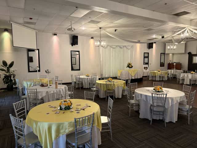 Main Banquet Hall with yellow table linens and ceiling draping for wedding or social event.
