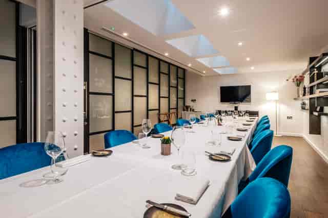 Private dining room with blue velvet chairs for luxury corporate events and business meetings.