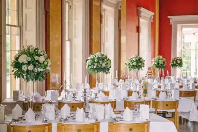 College Hall gala setup with tall floral centerpieces and elegant candelabras for luxury weddings.