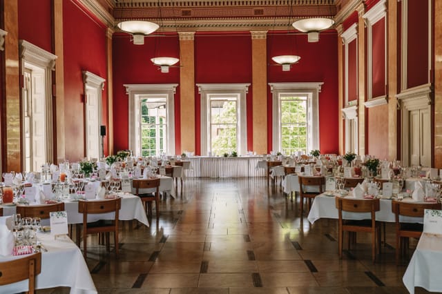 College Hall banquet room with red walls for corporate gala or wedding reception.