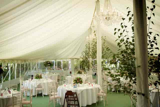 Luxury marquee wedding venue at Rectory Farm with crystal chandeliers and ivory linens.