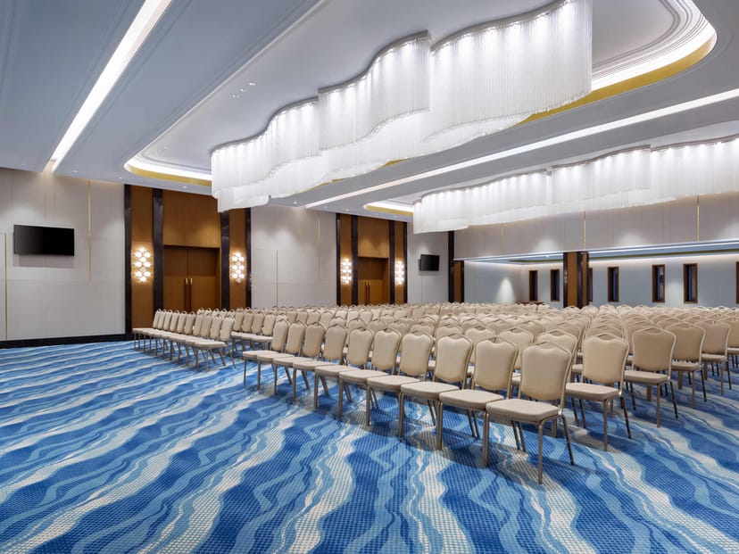Contemporary ballroom with sculptural ceiling at Swissôtel Almaty for corporate conferences.
