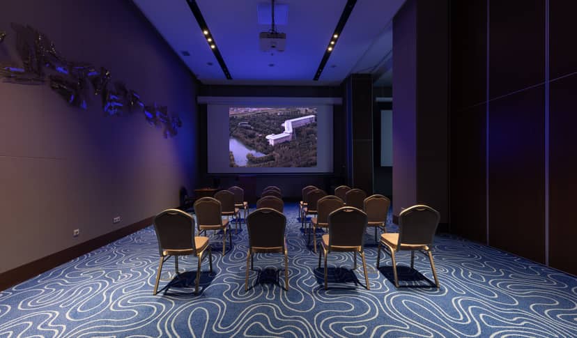 Theater-style meeting room at Swissôtel Almaty, featuring patterned carpet for corporate workshops.