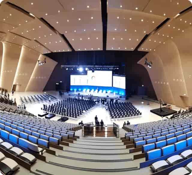 Modern plenary hall with raked seating at Astana Congress Center for keynote and panel events.