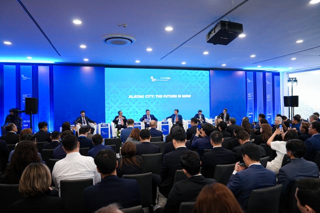 ALATAU Hall Korme Center: Blue corporate plenary stage with packed audience at B2B event.