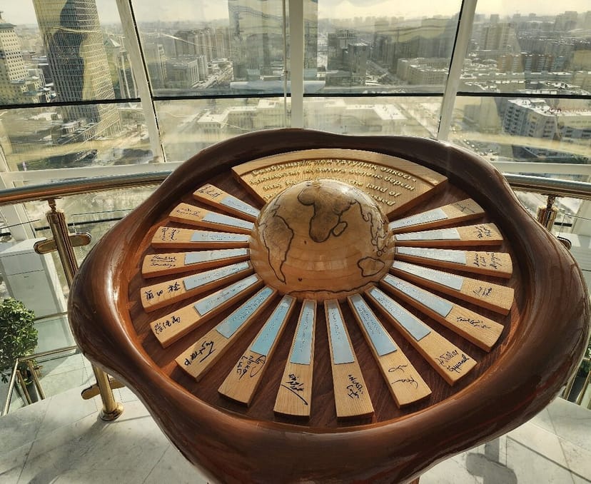 Baiterek Tower event registration desk with global-themed guestbook for corporate networking.
