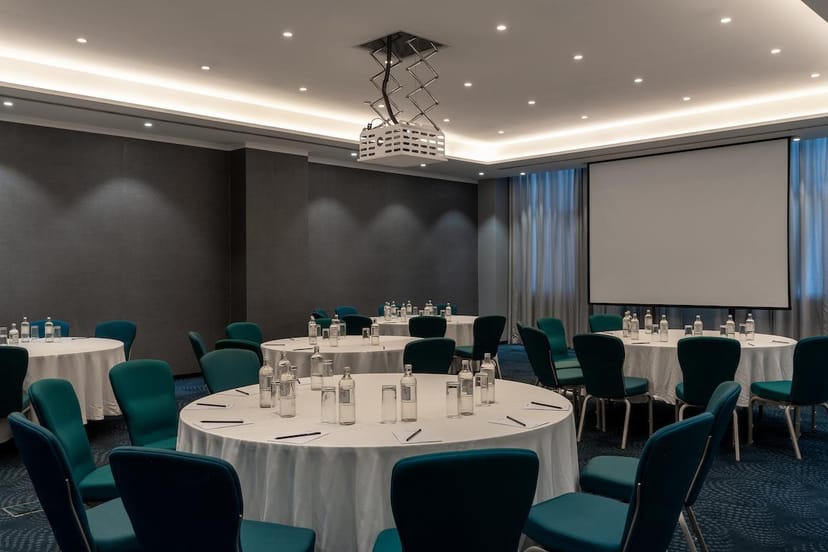 Banquet-style meeting room with teal chairs at Radisson Blu Nairobi for corporate conferences.