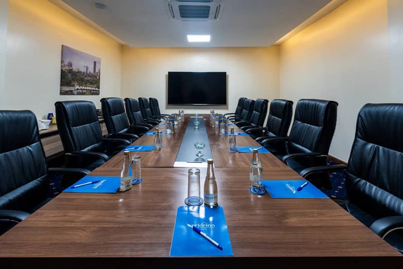 Jasmine A at a PrideInn Azure boardroom: executive meeting space with leather chairs.