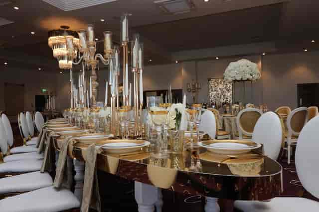 Luxury wedding banquet table with mirrored top and metallic candelabras at Rhema Suite gala.