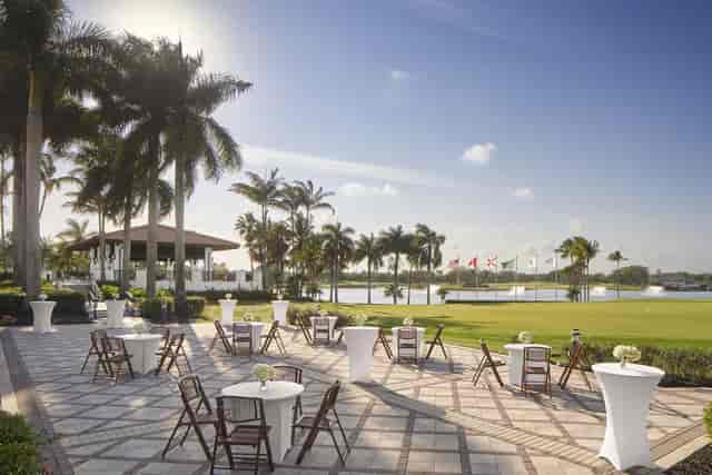 High-top tables on Garden Terrace with golf course views for outdoor cocktail networking events.