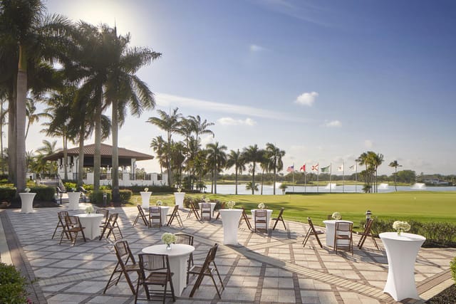 High-top tables on Garden Terrace with golf course views for outdoor cocktail networking events.