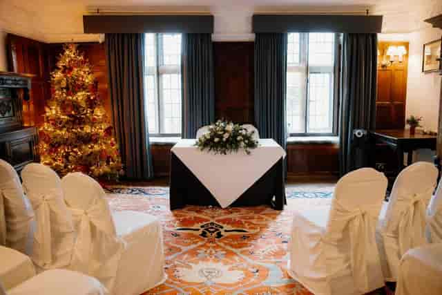 The Cromwell Room at The Lygon Arms set for a boutique wedding ceremony with wood paneling.