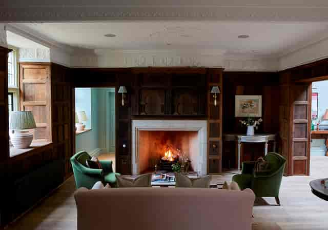 Hearth Room lounge with wood paneling and fireplace for networking events and meetings