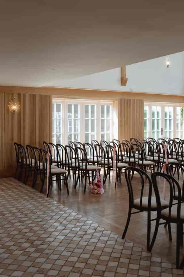 Elegant ceremony setup at Millbridge Court with wood paneling for luxury wedding event photography.