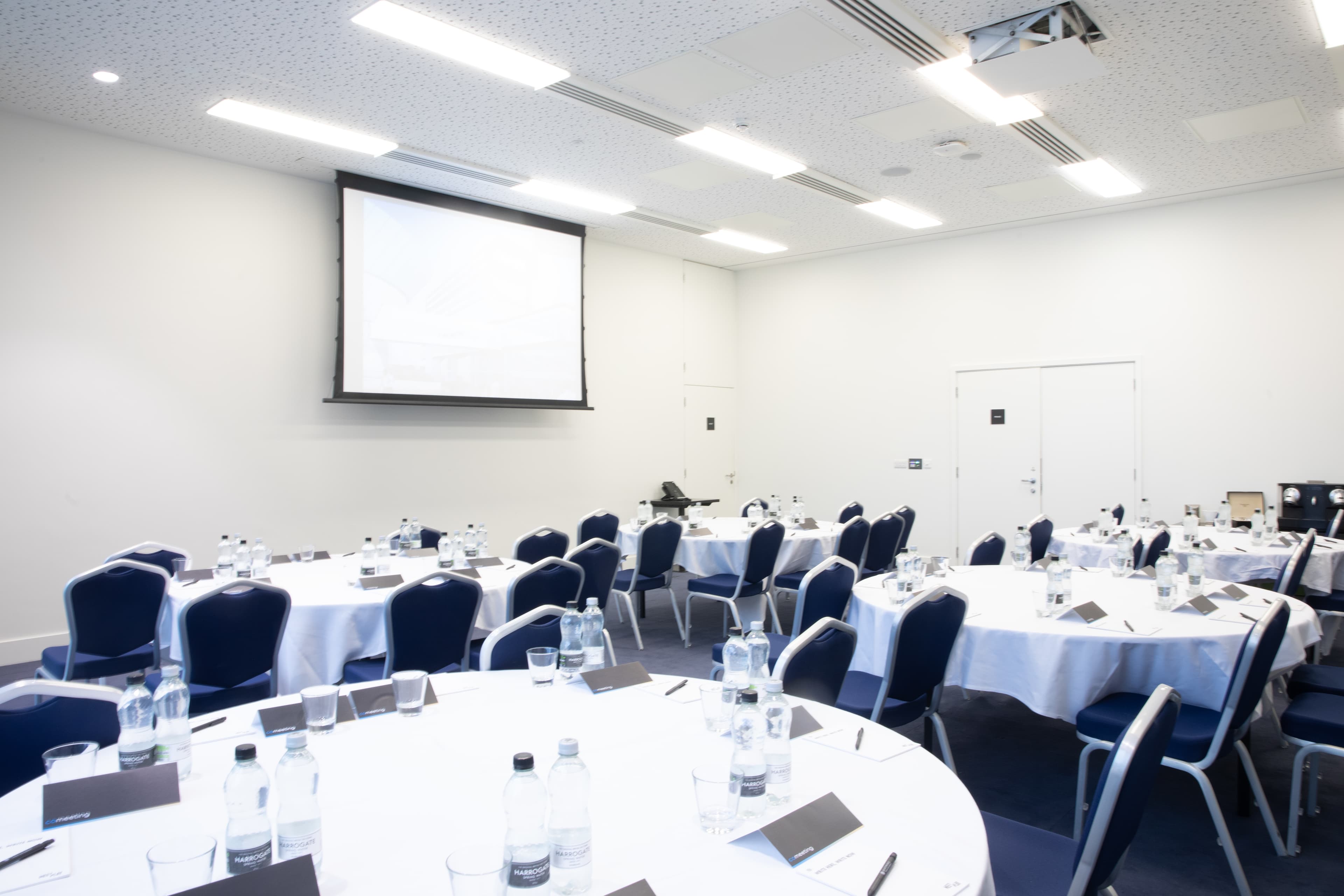 PANAM private function area with round workshop tables and AV setup for corporate events.