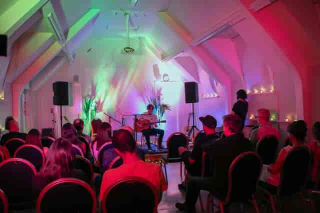 The Old Chapel at London Irish Centre: vaulted event space with atmospheric colored lighting.