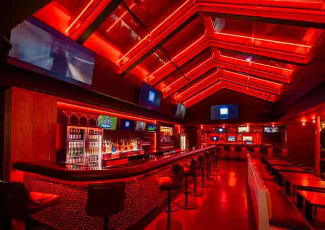 Main bar at The Hatch Club with bold red decor for corporate mixers and evening networking events.