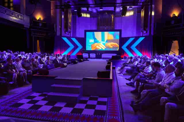 Historic Grand Temple theater-style conference venue with modern LED screen and ambient lighting.