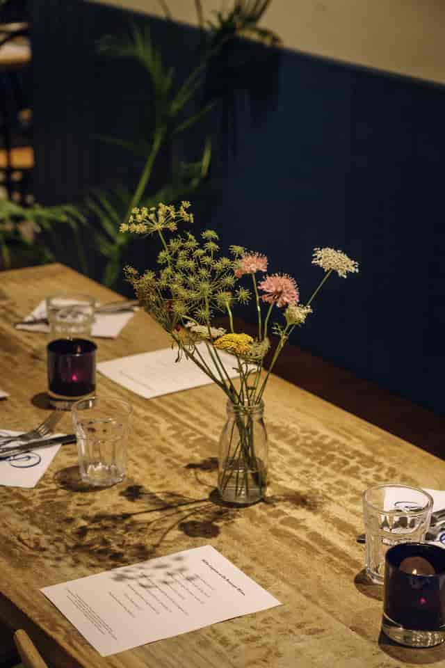 Rustic tablescape with wildflower centerpieces for corporate dinner or sustainable event venue.
