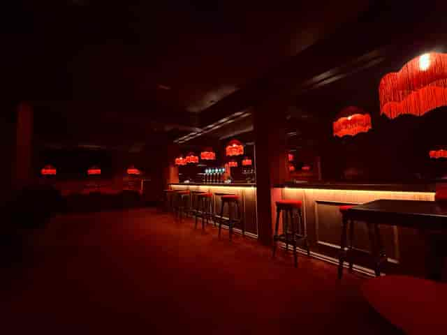 Moody red lounge bar with fringe accents for VIP receptions and brand activations.