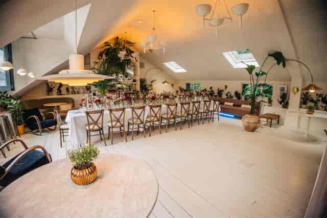 Luxury conservatory venue set for a corporate banquet dinner with elegant long-table seating.