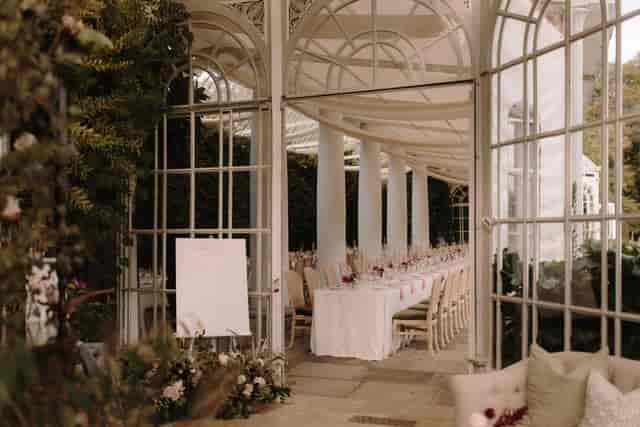 Al fresco wedding reception in a glass conservatory at Wellness & Wilde, elegant event venue.