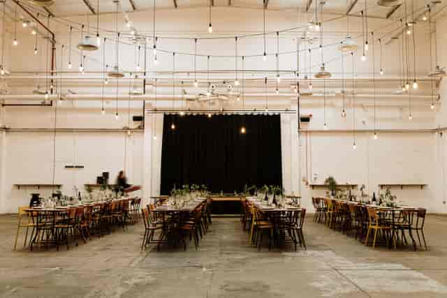 Industrial-chic Garden Room venue with Edison lights for modern banquet or gala events.