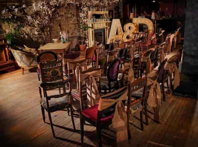 Boho-chic wedding ceremony setup with vintage chairs at The Lamp House rustic event venue.