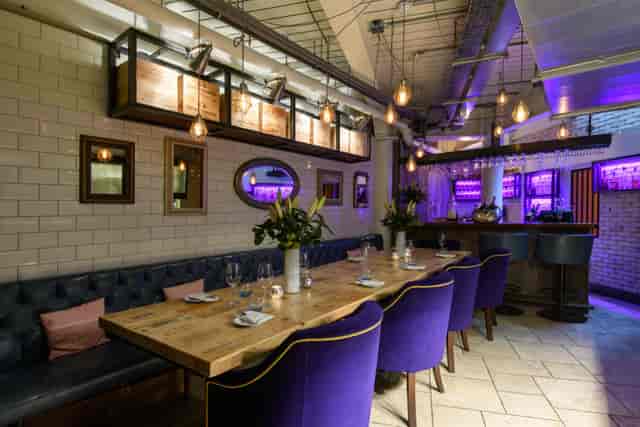 Private dining venue with purple lighting for upscale team dinners and networking events.