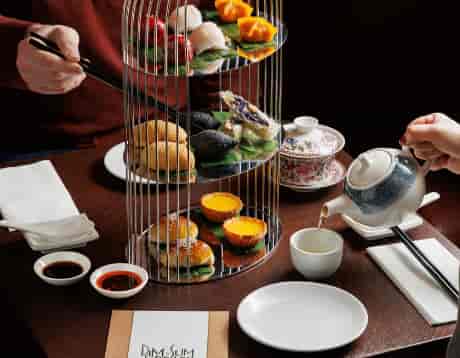 Multi-tiered dim sum display at high-end networking event venue.