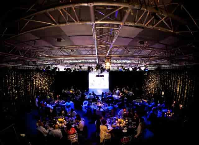 Industrial event space at The Studio, Rich Mix with banquet seating and dramatic fairy lights.