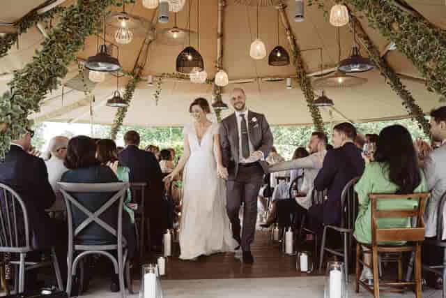 Lanes of Lymington luxury tented wedding ceremony with Edison lighting and organic greenery.