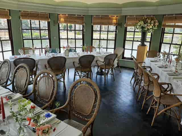 The Boathouse at The Mitre: riverside venue with rattan seating for private dining and corporate events.