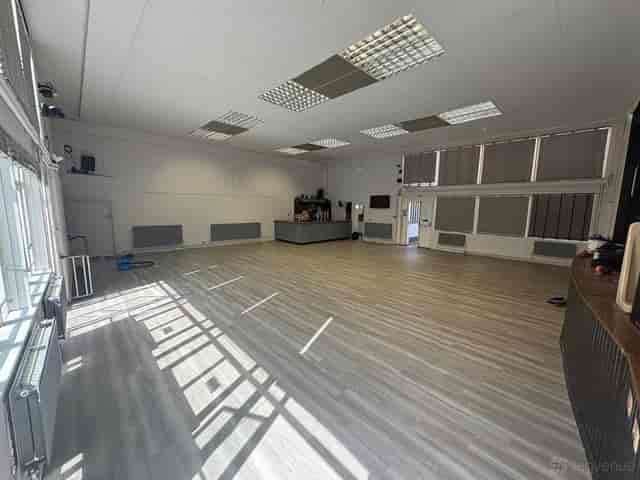Small Hall event venue with modern flooring, perfect for social gatherings and corporate workshops.