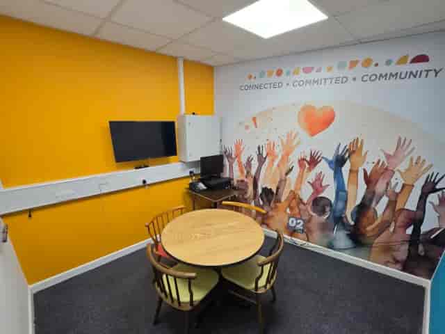 Woolwich huddle room with circular table and mural for small-group collaboration and team meetings.