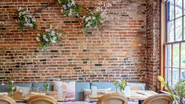Upstairs event space with exposed brick, floral decor, natural light for intimate meetings