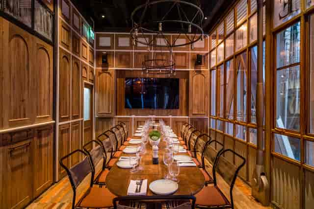 Intimate rustic dining room with wooden table and screen for meetings at Riding House Café