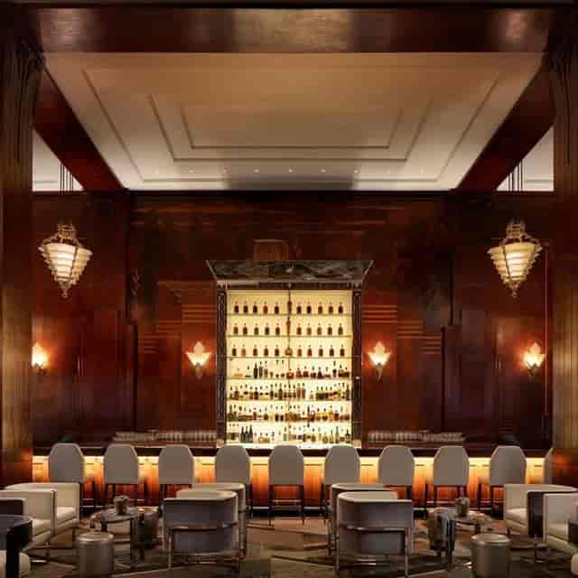 Elegant Italian wine bar with backlit bottles, polished counter for upscale networking events