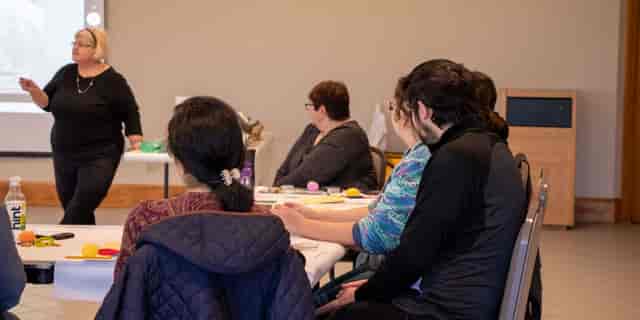 Small-group workshop at Forest Gate Classroom, London exam centre with collaborative tables.