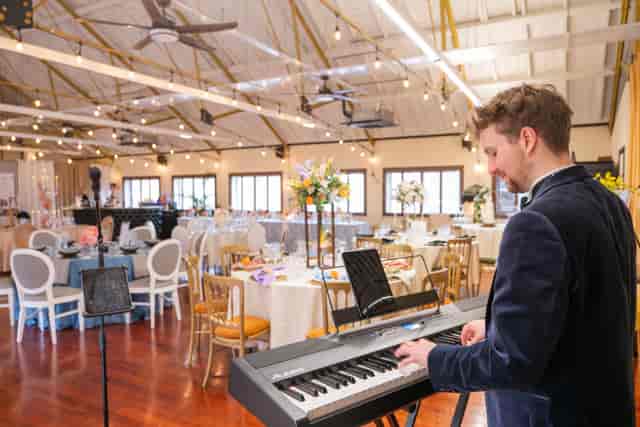 Banquet setup at Lumiere Underwood with industrial rafters, string lighting, and live music.