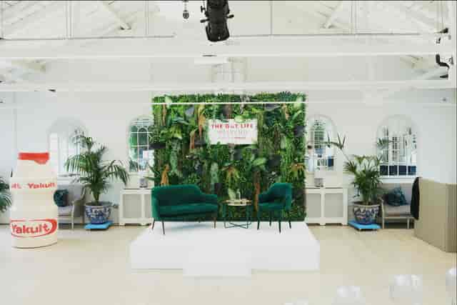 Brand activation stage with green wall backdrop for corporate events and product launches.