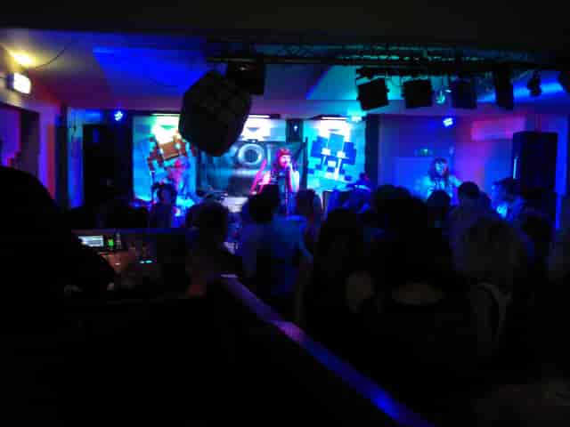 High-energy evening reception at The Portland Arms featuring dynamic stage lighting and nightclub vibe.