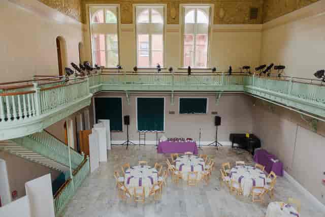 NCI Centre Main Hall heritage venue set for an intimate banquet with dramatic balcony lighting.