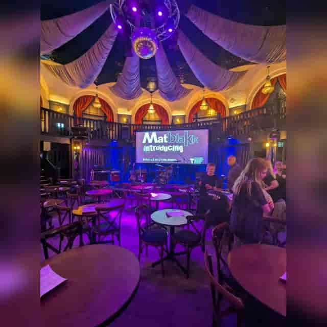 Branded corporate event at The Bedford Saloon featuring dramatic ceiling draping and AV projection.