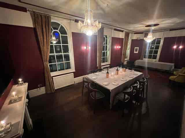 Elegant private dining room with crystal chandelier for corporate meetings or exclusive events.