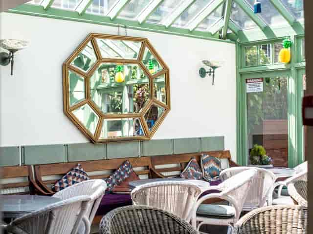 Sun-drenched Conservatory glass breakout space for casual networking and corporate team meetings.