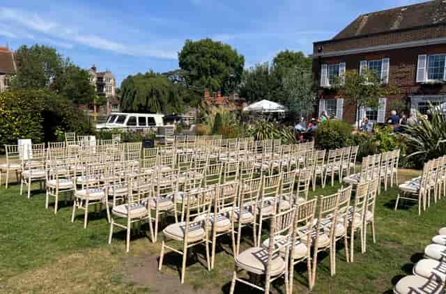 Outdoor garden wedding venue with gold Chiavari chairs for ceremonies.