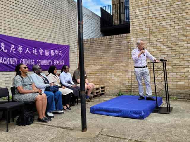 Outdoor community event at ESEA Centre with branded backdrop and speaker stage.