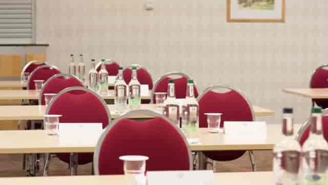 Boardroom setup with red chairs at Future Inn Cardiff, ideal for corporate meetings and conferences.