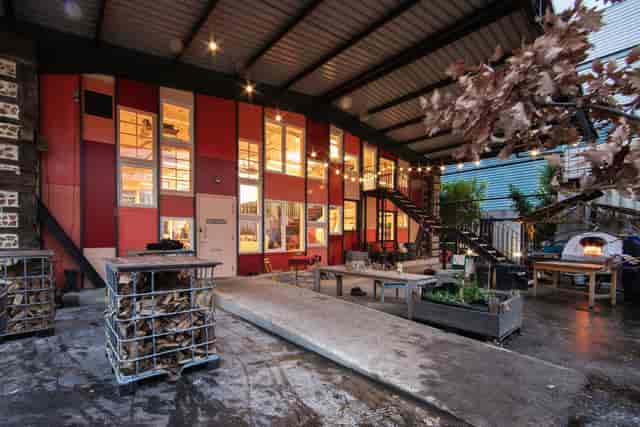 Industrial-chic Paper Garden meeting room with wood-fired oven for experiential corporate events.